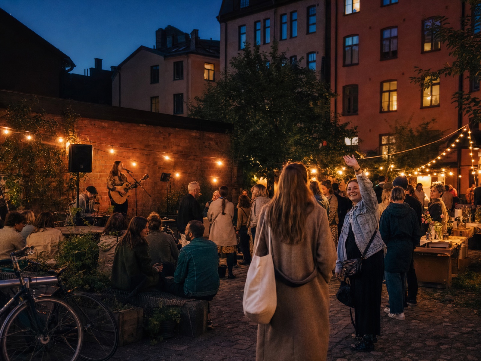 Neighbours gathering for a small courtyard concert and market in Stockholm as one friend waves another over